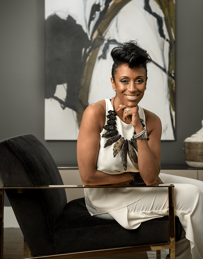 top NYC interior designer sitting in black chair wearing white dress